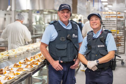 Two instructors stand in the commercial kitchen